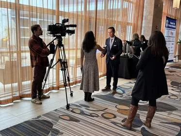 News crew filming interview with NY State Assemblyman Angelo Santabarbara at Tech Valley Cybersecurity Symposium